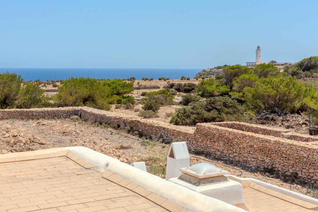 ein Blick auf eine Steinmauer mit dem Meer im Hintergrund in der Unterkunft Agroestancia Can Toni Puig in La Mola