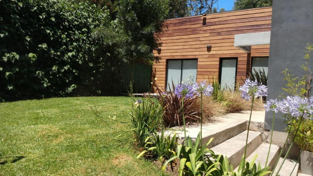 a house with a garden with flowers in front of it at Casa Fresno Casas Atahualpa 2 in Mar del Plata