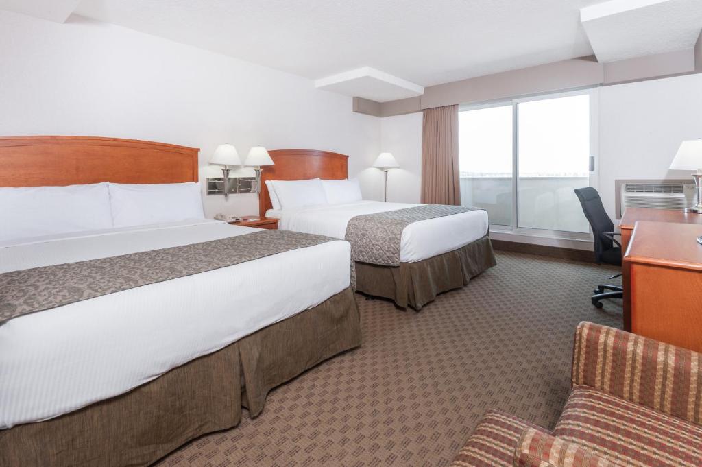 Postel nebo postele na pokoji v ubytování Ramada by Wyndham Edmonton South