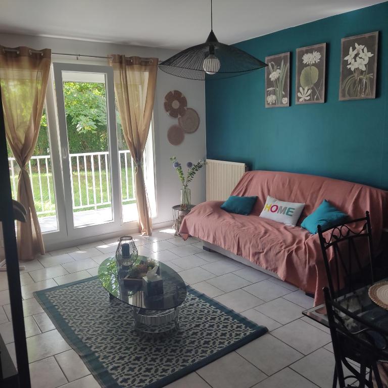 un salon avec un canapé et une table dans l'établissement Au nid carolo, à Charleville-Mézières