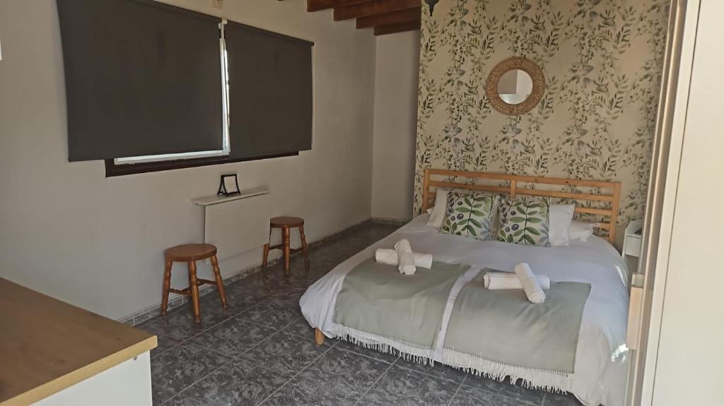 a bedroom with a bed and two stools at Habitación en Terraza de Apartamentos Playa Hermigua in Hermigua