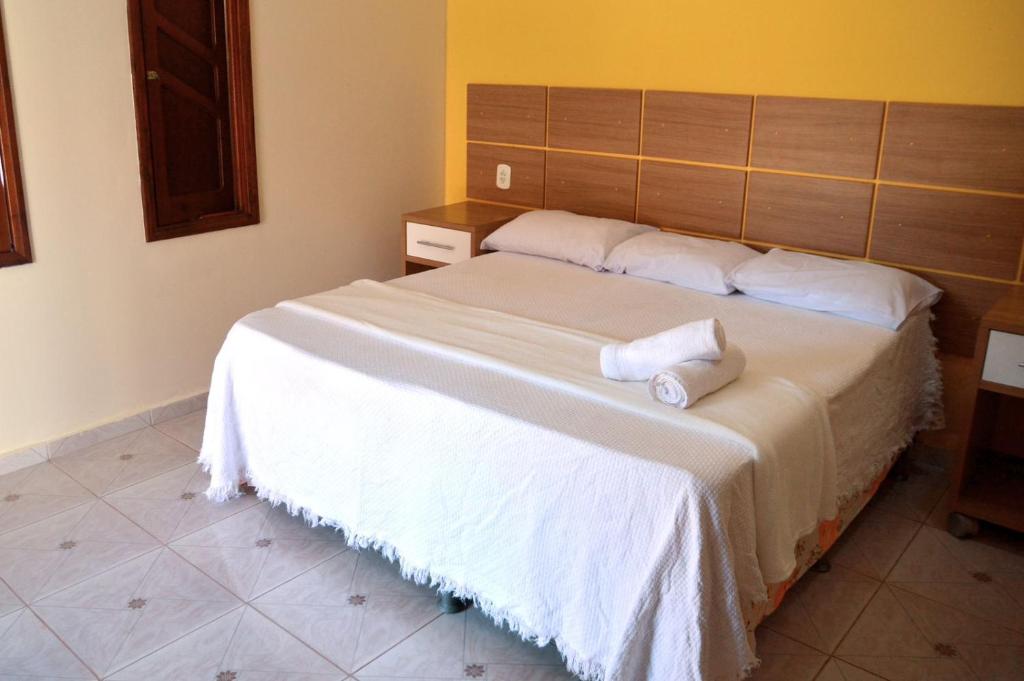 a bedroom with a bed with two towels on it at Pousada Cunhantã in Alter do Chao