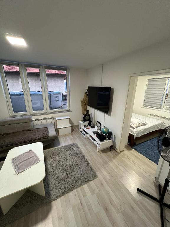 a living room with a couch and a flat screen tv at Make Apartments in Sarajevo