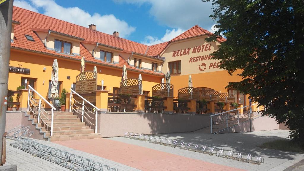 a yellow building with stairs in front of a restaurant at Pelikan Purkarec in Hluboká nad Vltavou