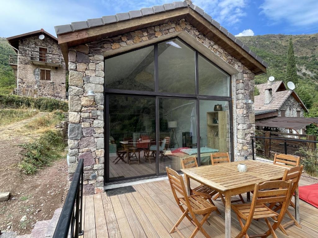un patio avec une table et des chaises sur une terrasse dans l'établissement Maison Gaia, à Valdeblore