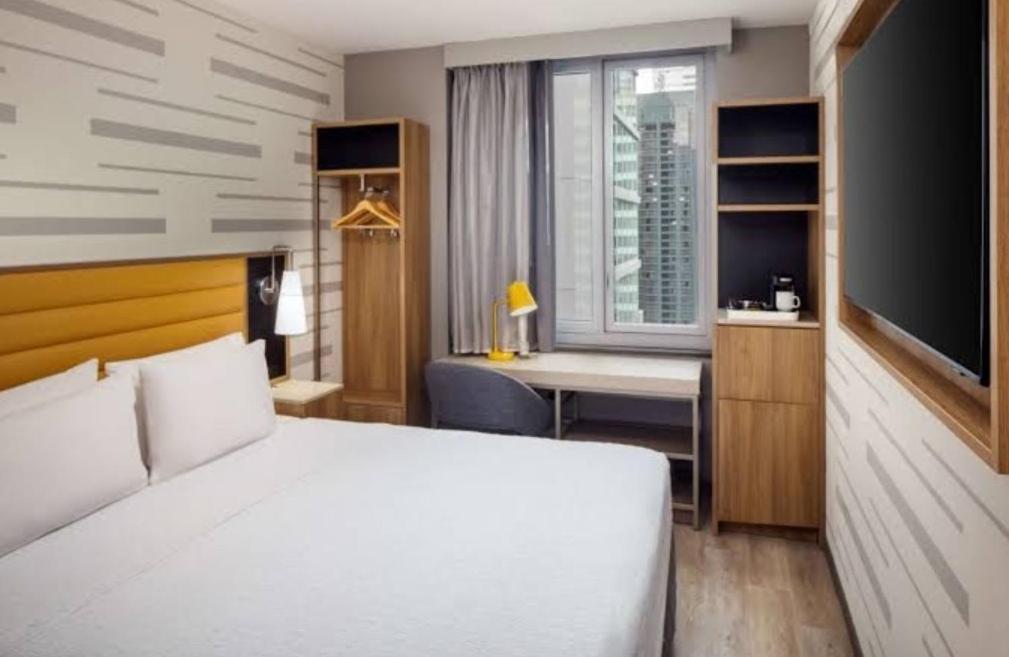 Un dormitorio con una cama, un escritorio y un televisor. en Home2 Suites By Hilton Thomasville, en Thomasville