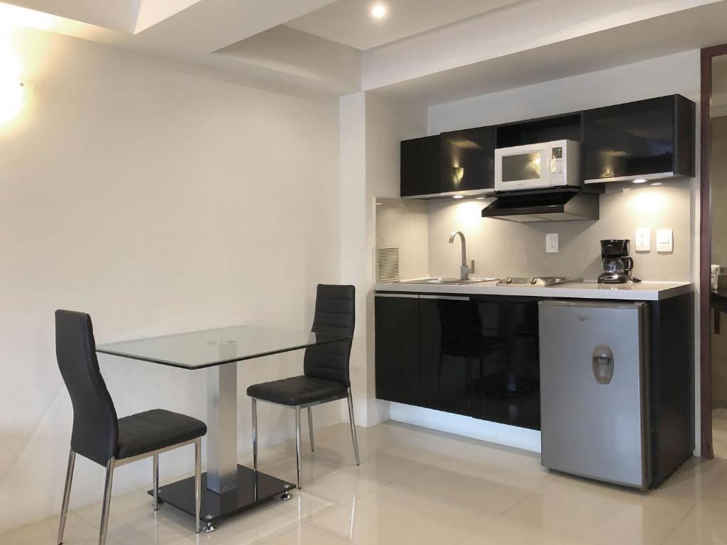 A close view of the suite’s fitted kitchenette beside a two-person dining table.