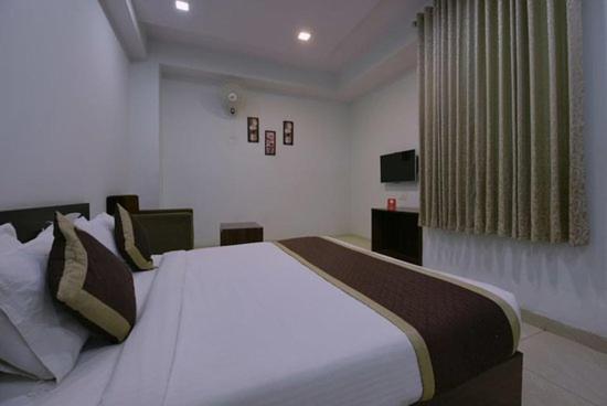 a bedroom with a large white bed in a room at Hotel Anugraha in Kalyānpur