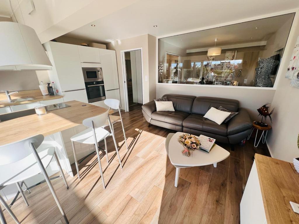 un salon et une cuisine avec un canapé et une table dans l'établissement Village naturiste - La villa nature -, au Cap d'Agde