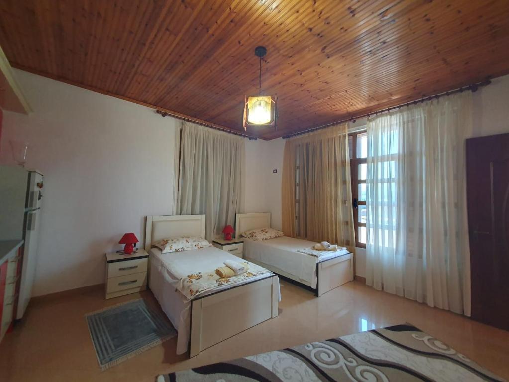 a bedroom with two beds and a wooden ceiling at Sara Guesthouse in Berat