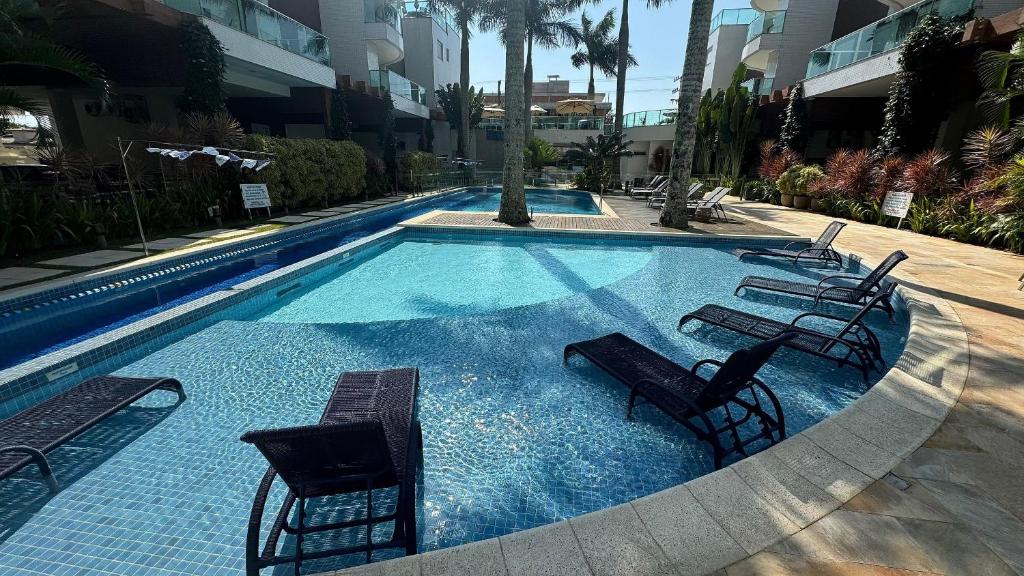 邦比尼亚斯Espetacular Apartamento em Condomínio com Piscina e Spa - Boulevard Bombinhas的一个配有椅子和桌子的大型游泳池