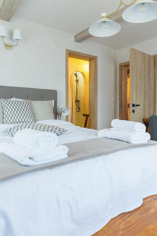 a bedroom with a white bed with towels on it at Rustic Inn bed and breakfast in Budeşti
