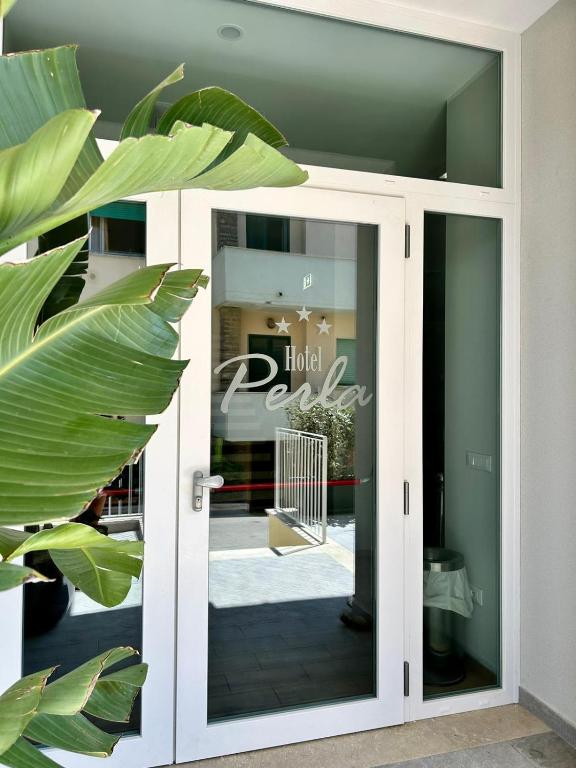 a door to a store with a sign on it at Hotel Perla in Castiglione della Pescaia