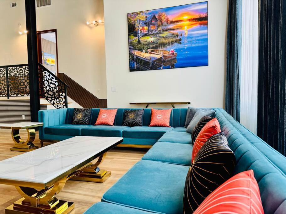 a living room with a blue couch and a table at Downtown Dreaming Alex City Near Lake Martin in Alexander City