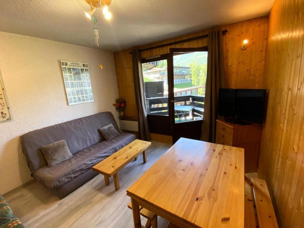 un salon avec un canapé et une table en bois dans l'établissement Résidence Les Orrianes Des ForÊts - Appartement spacieux au coeur des Orres 1650 MAE-8921, aux Orres