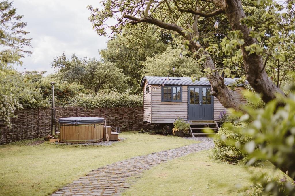 a tiny house in a garden with a brick wall at The Starlight Hideaway in Hull