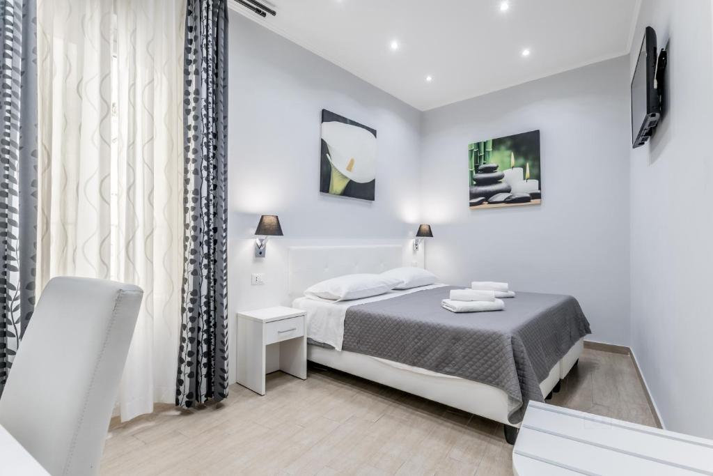 a white bedroom with a bed and a window at Vatican Sweet Guest House in Rome