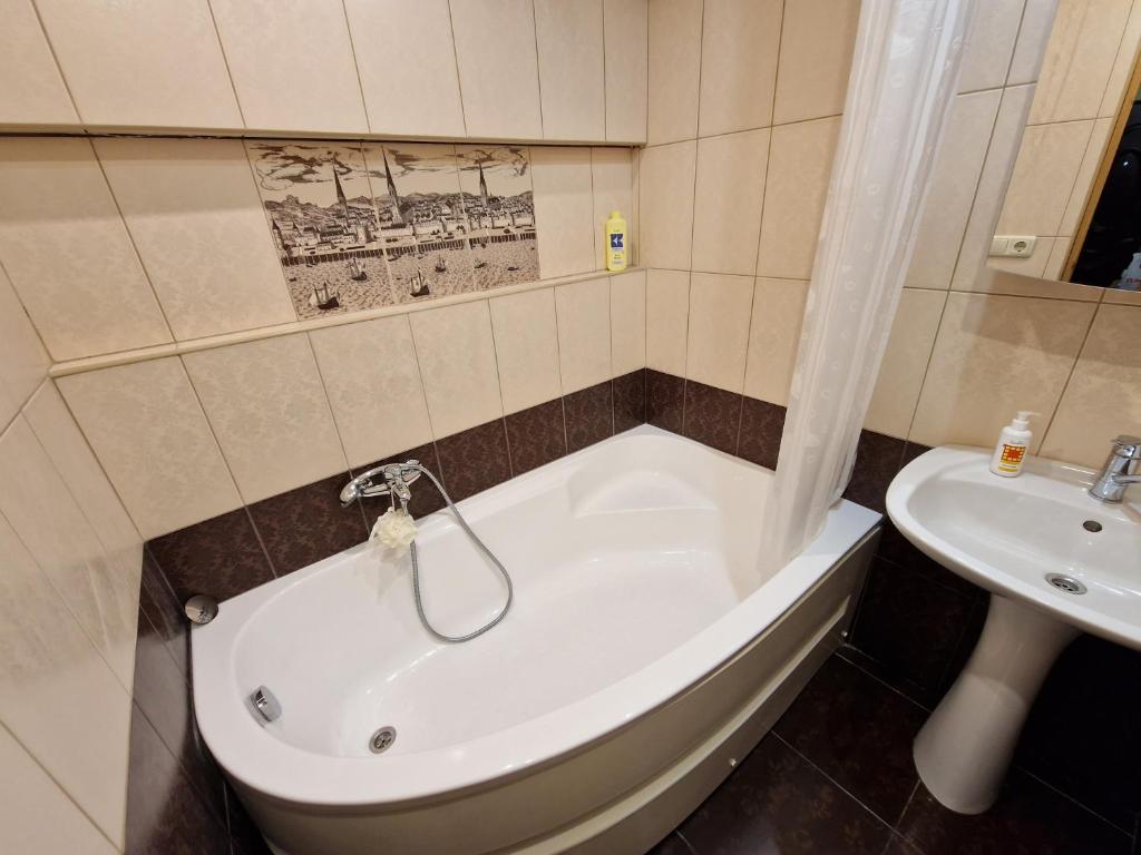 a bathroom with a tub and a sink at Wind City Apartament in Liepāja