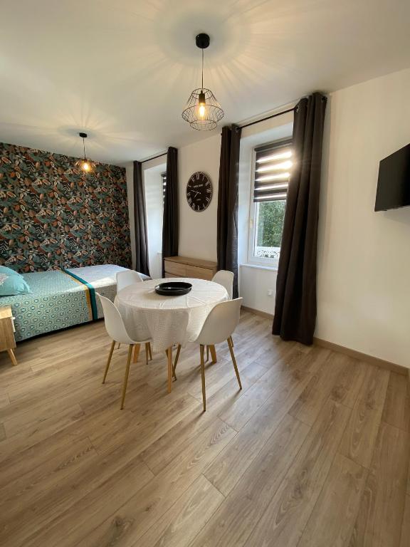 une pièce avec une table, des chaises et un lit dans l'établissement Studio 1er étage - Centre-ville - Local vélos disponible, à Mayenne