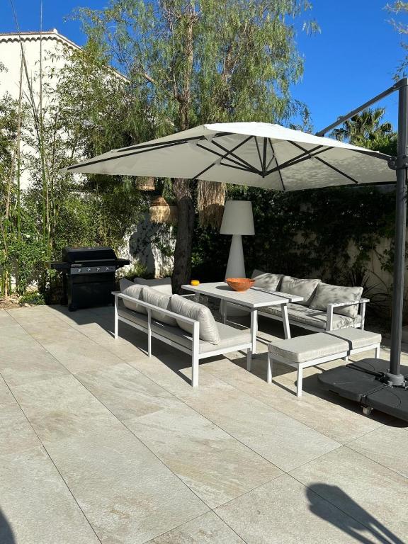un patio avec une table et un parasol dans l'établissement Villa ELEMIAH, à Saint-Tropez