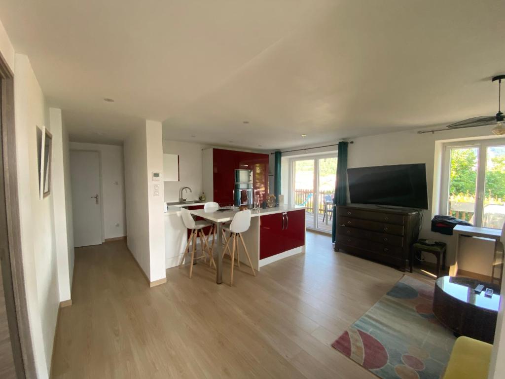 une cuisine et un salon avec une table et des chaises dans l'établissement Appartement coquet avec 3 chambres en face des pistes de ski, à Gérardmer