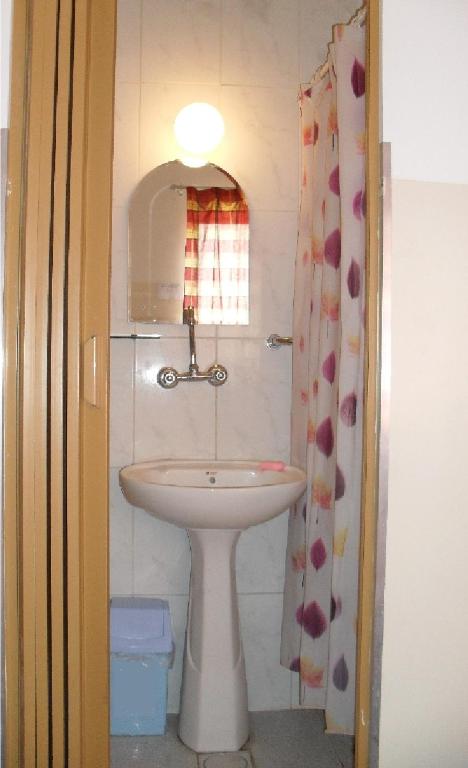 ein kleines Badezimmer mit Waschbecken und Spiegel in der Unterkunft Farah Hotel in Amman