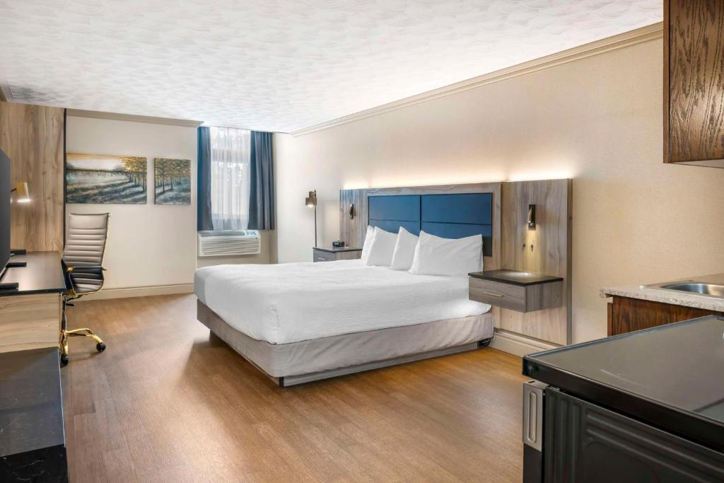 a hotel room with a bed and a kitchen at Best Western Plus Edmundston in Edmundston