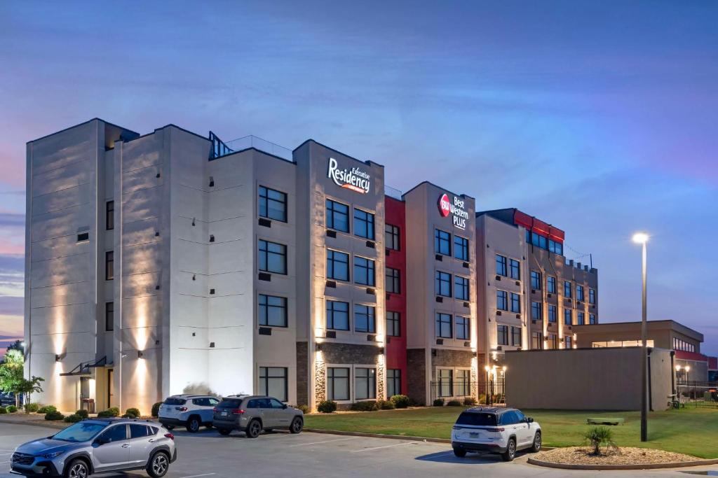 a building with cars parked in a parking lot at Best Western Plus Executive Residency Rigby's Water World Hotel in Warner Robins