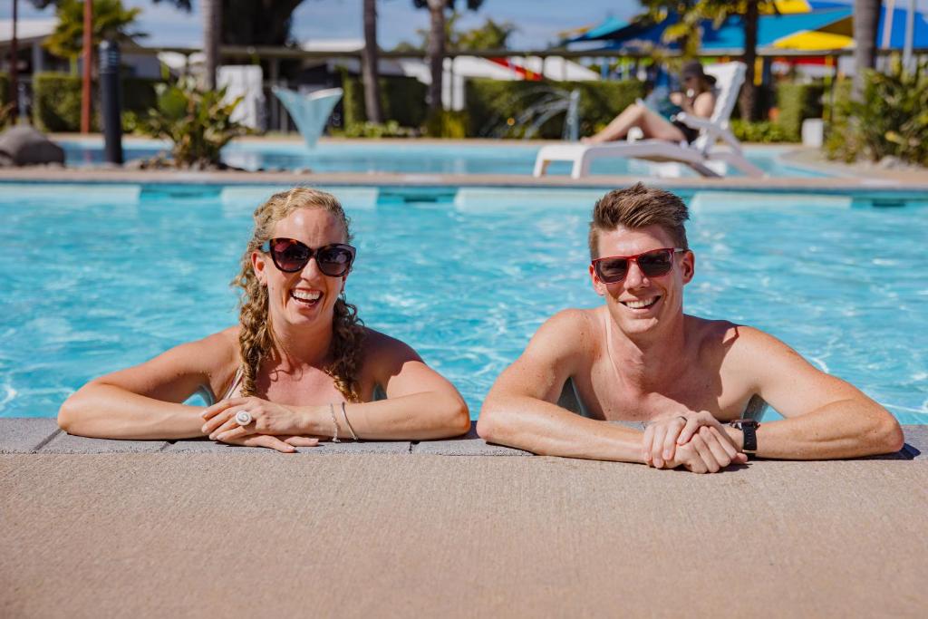 mężczyzna i kobieta leżący w basenie w obiekcie Kennedy Park Resort Napier w mieście Napier