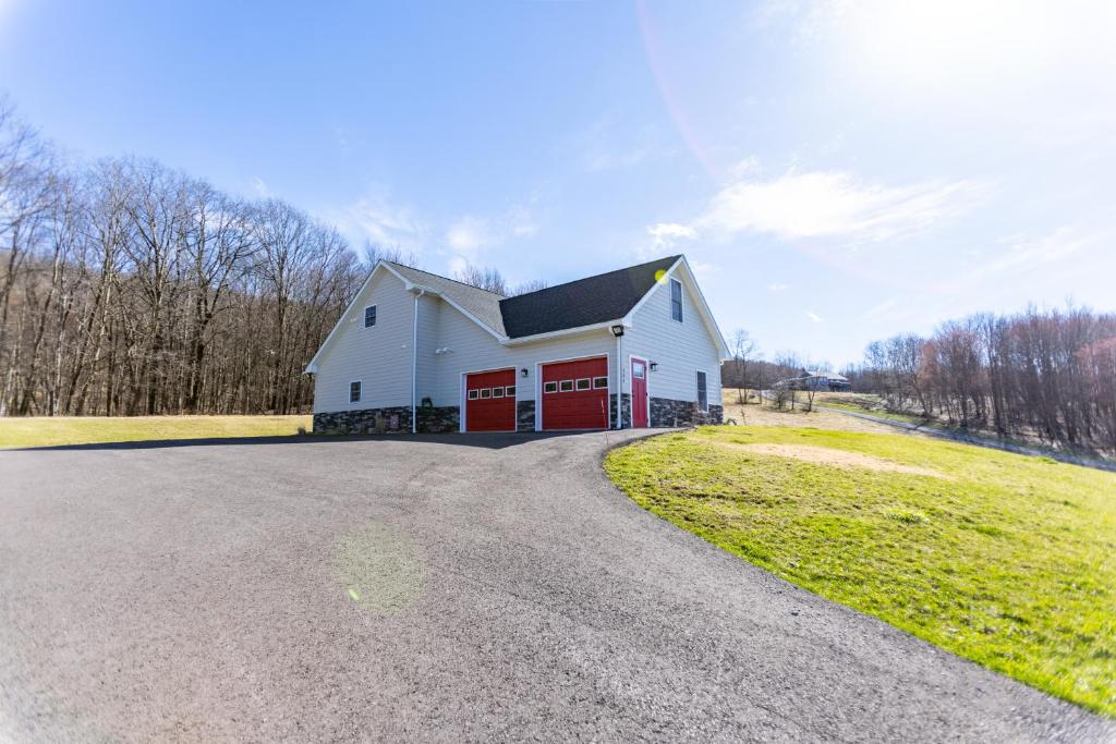 a white barn with red doors on a road at Deep Creek Retreat Hot Tub 85 inchTV all one level in Accident