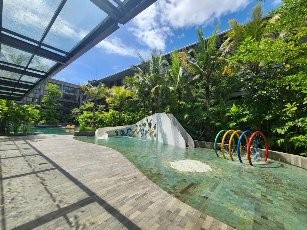 een zwembad met een glijbaan in een resort bij de' Asasta Apartment Benoa E216 in Nusa Dua