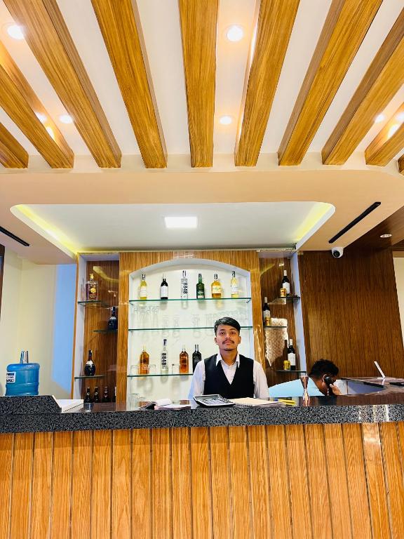 un hombre sentado en un bar en un restaurante en Hotel Nirakar, en Katmandú