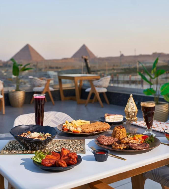 un tavolo con molti piatti di cibo sopra di Royal Great Pyramid INN a Il Cairo