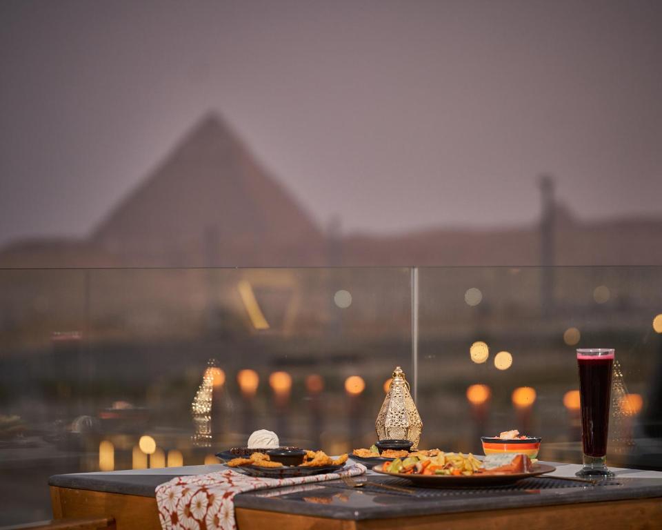 un tavolo con due piatti di cibo e una bevanda di Royal Great Pyramid INN a Il Cairo