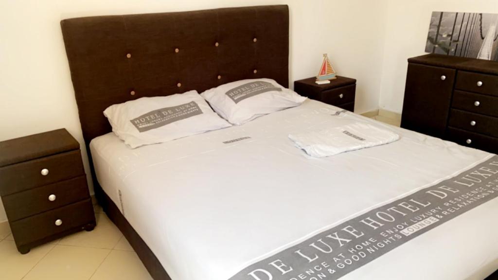a bedroom with a large white bed with two night stands at Appart cosy 5 min plage in Gaams