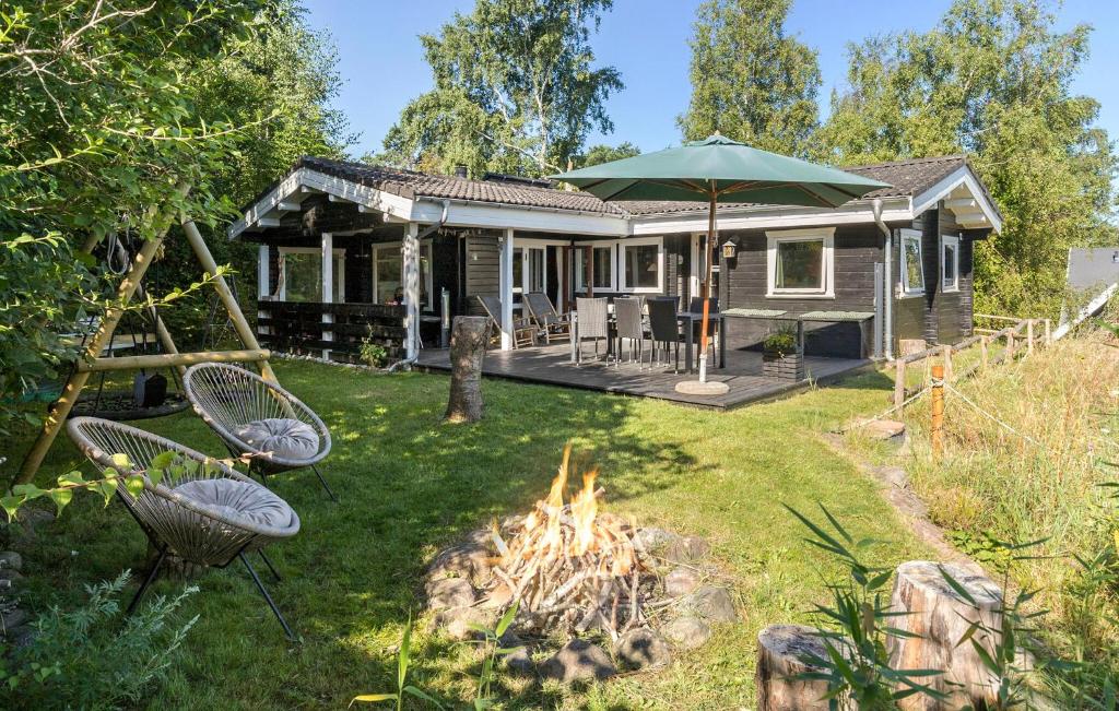 a small house with a fire in the yard at Holiday Home Tværvangen in Ebeltoft