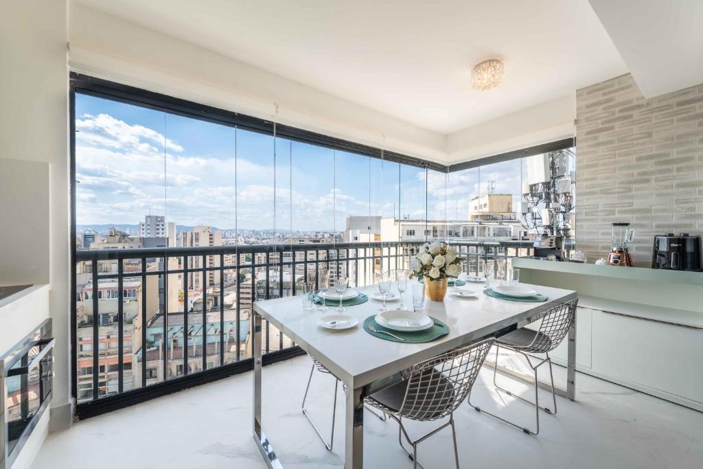 a dining room with a table and a large window at Apartamento luxuoso 178 São João in Sao Paulo