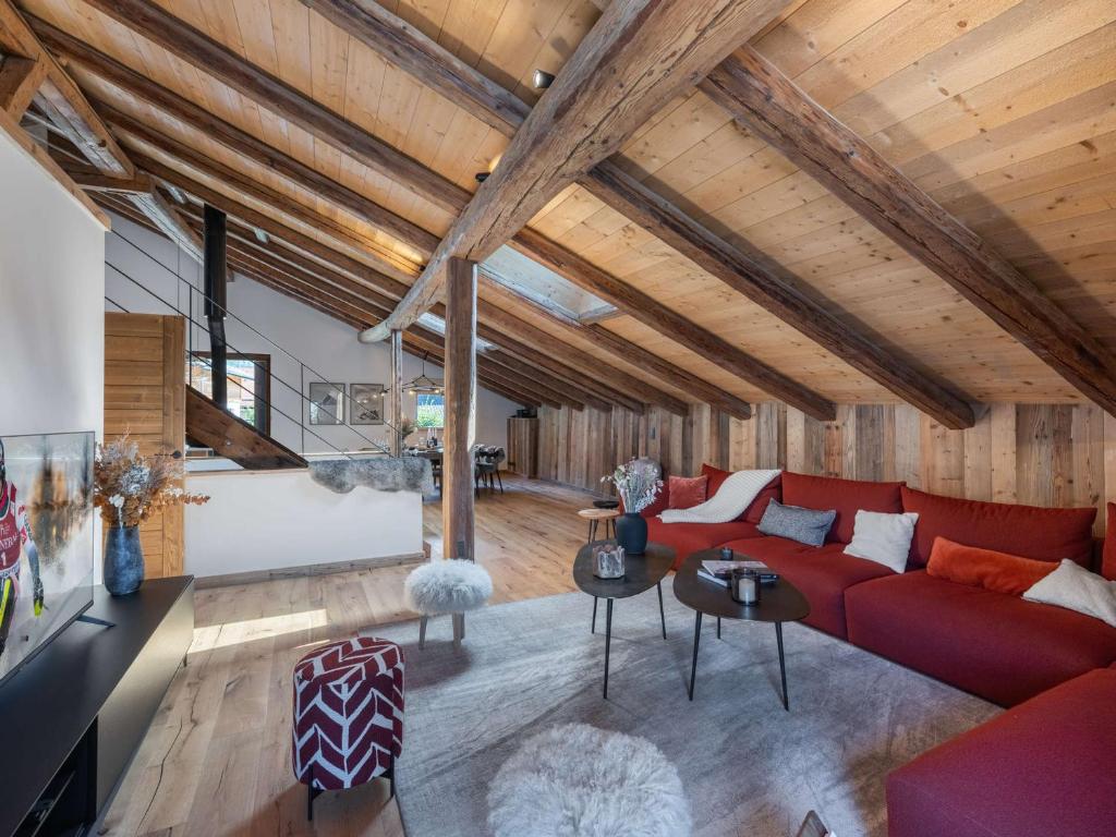 ein Wohnzimmer mit einem roten Sofa und Holzdecken in der Unterkunft Chalet chaleureux 10 pers, parking Saint-Gervais - FR-1-663-23 in Saint-Gervais-les-Bains