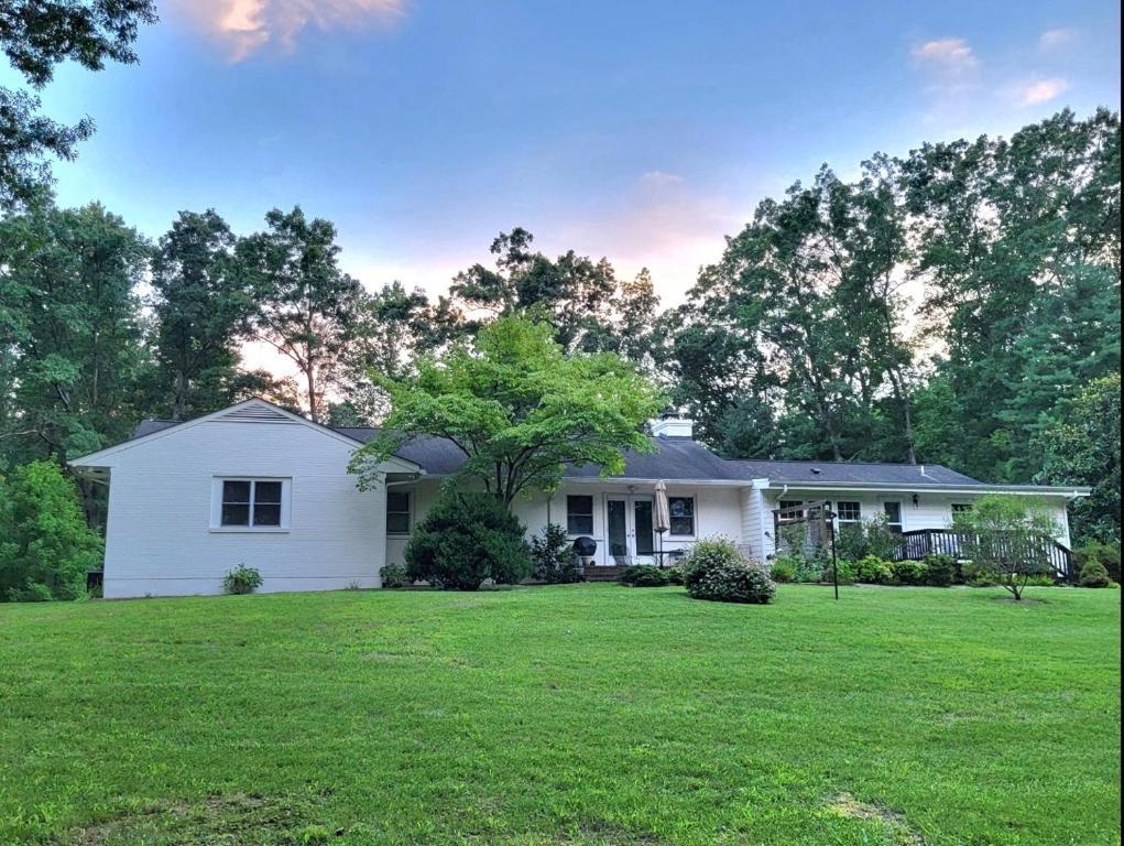 a white house with a tree in a yard at Meadow View Acres - 6 acre spacious estate 20 min from UVA in Charlottesville