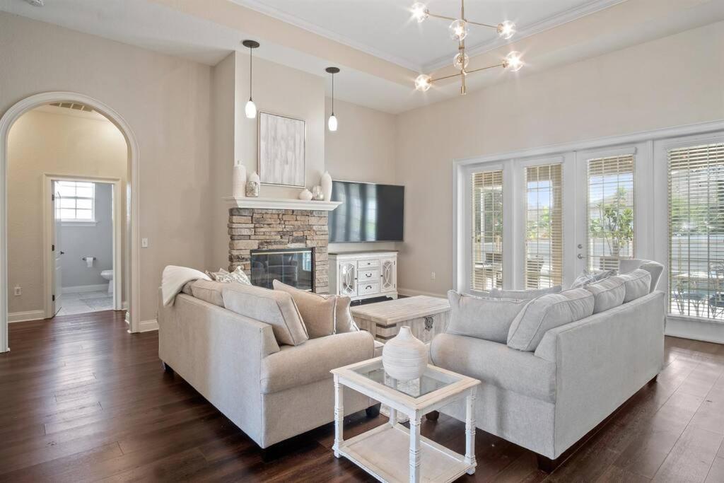 a living room with two couches and a fireplace at Luxury Heated Pool Home, Hot tub, King bed suite in Lakeland