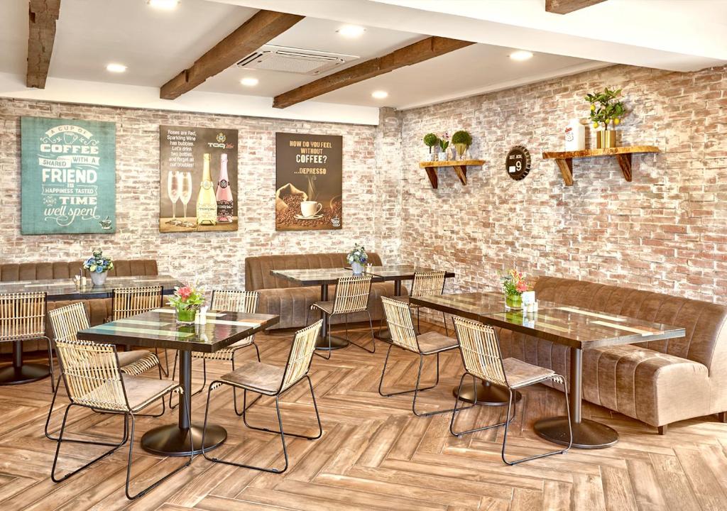 a restaurant with tables and chairs and a brick wall at Tag Resort in Coron