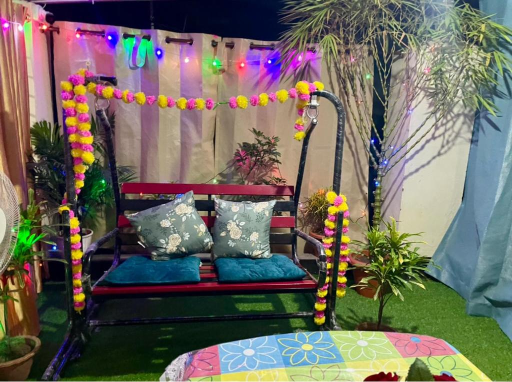 a bench in a yard with colorful lights and plants at Namaskar Lodge and Homestay in Guwahati