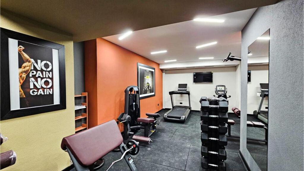 a gym with exercise equipment in a room with orange walls at Apartment Aurora in Bjelašnica