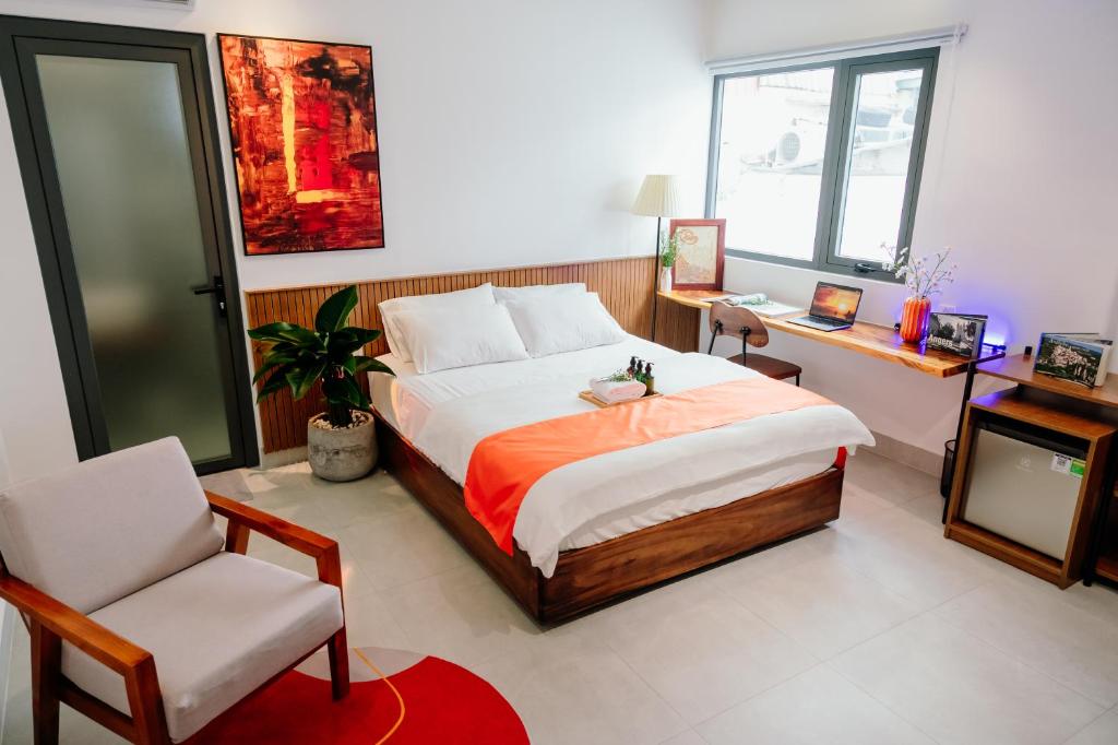 a bedroom with a bed and a chair and a desk at Urban Hotel in Ho Chi Minh City
