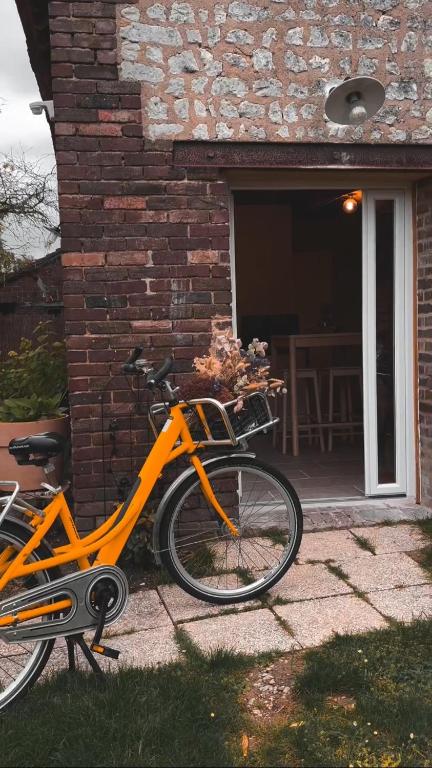 un vélo orange garé devant une maison en briques dans l'établissement La mise en Seine, à Venables