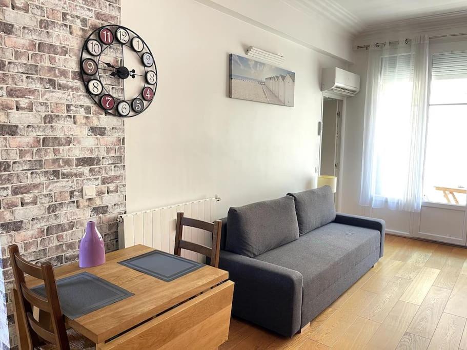 - un salon avec un canapé, une table et un réveil dans l'établissement Nice Les palais de la Med, à Nice