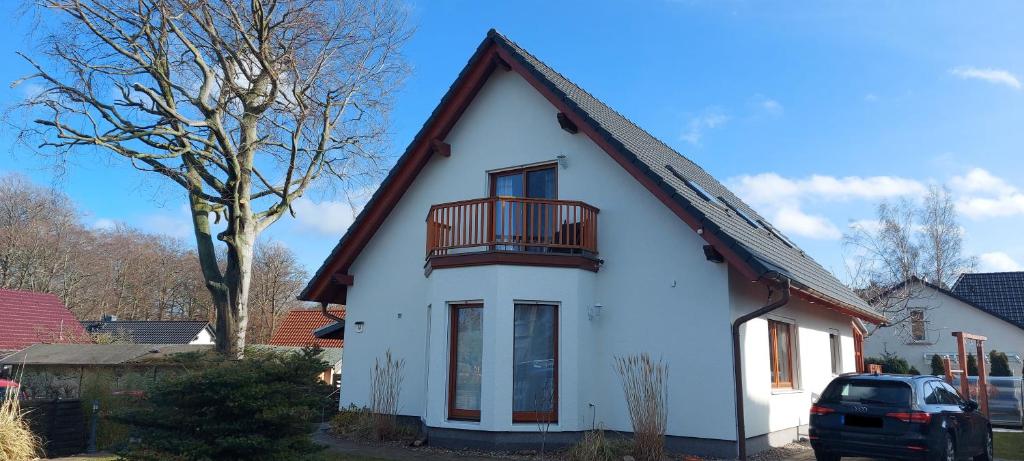 a white house with a balcony on top of it at Moderne Ferienwohnung "Parkblick" im Ostseebad Ückeritz in Ueckeritz