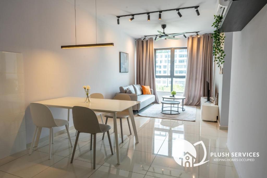a dining room and living room with a table and chairs at Gaia Residences by Plush in Rawang