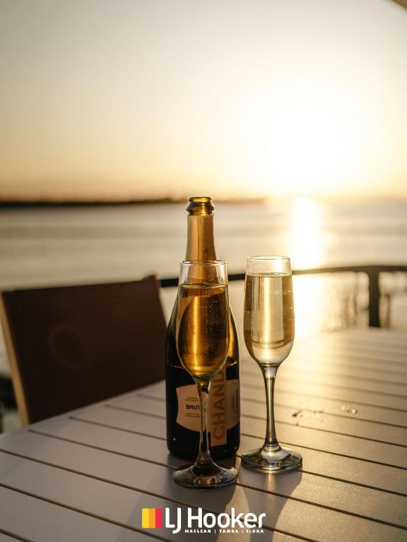 a bottle of champagne and two glasses on a table at Riverview Apartment 2.4 in Iluka