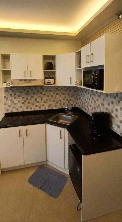 a kitchen with white cabinets and a sink at Avida Davao Condos, downtown CM Recto Avenue, Davao City in Davao City